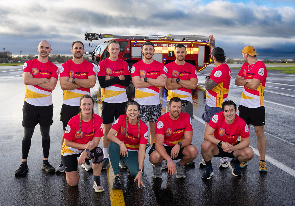 A group image of the team, with a fire appliance in the background, after having concluded the challenge after a finale run at RAF Brize Norton on Friday 12 December